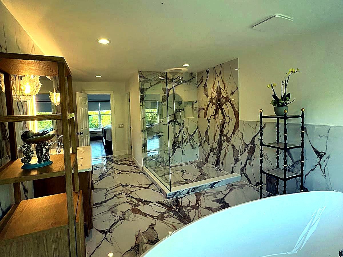 Marble primary bathroom with freestanding tub and glass shower