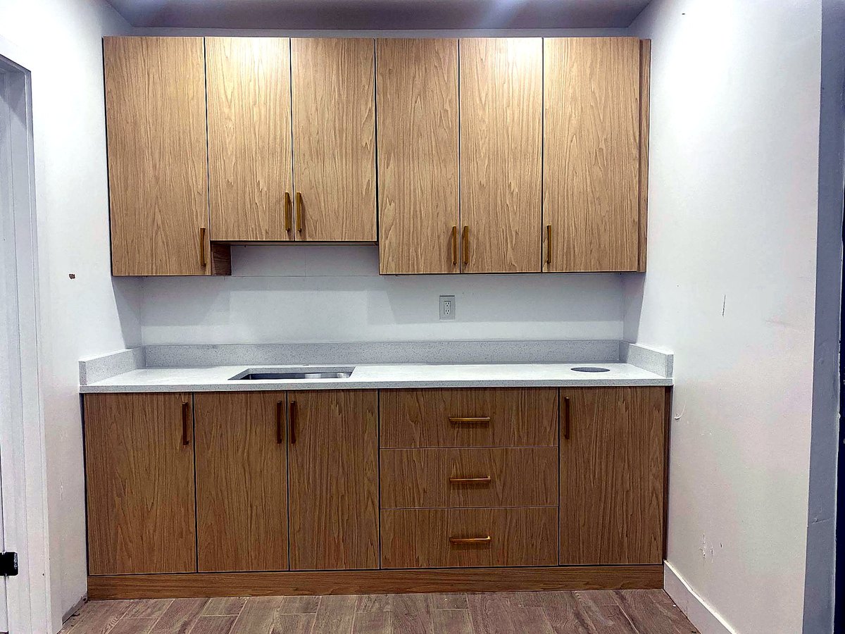 Custom oak cabinetry with brass hardware and quartz counter
