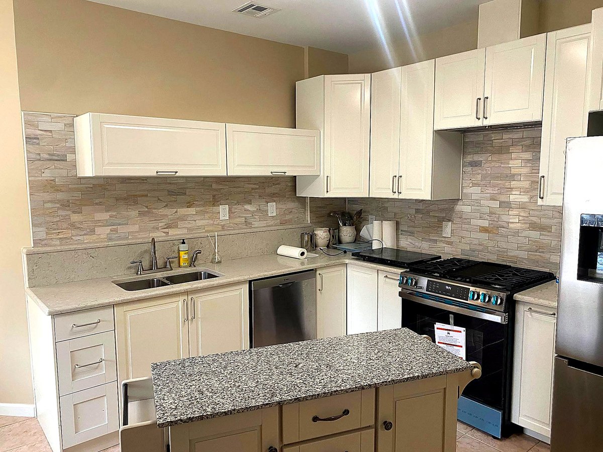 Kitchen with white quartz island and dark cabinetry