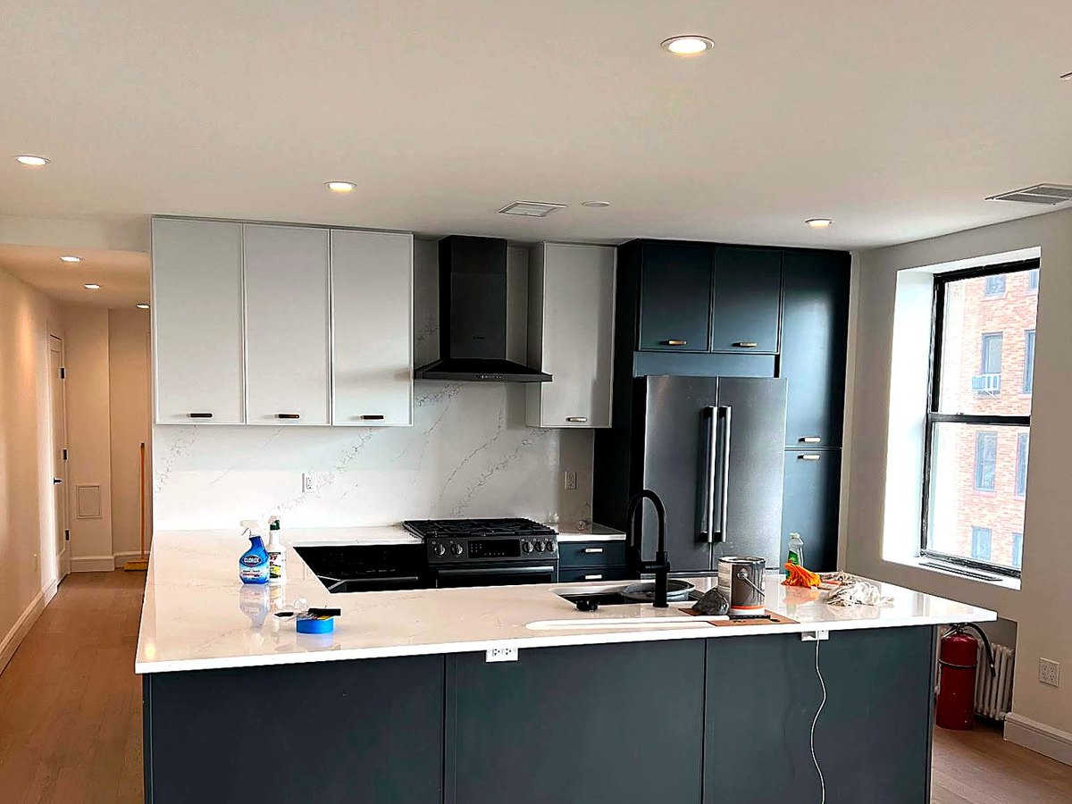 Kitchen with navy cabinetry and stainless steel refrigerator