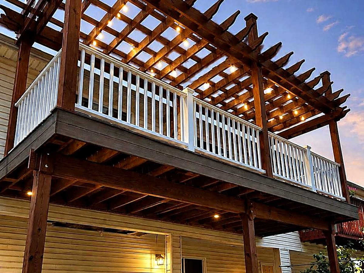 Two-story deck and pergola at dusk with string lighting